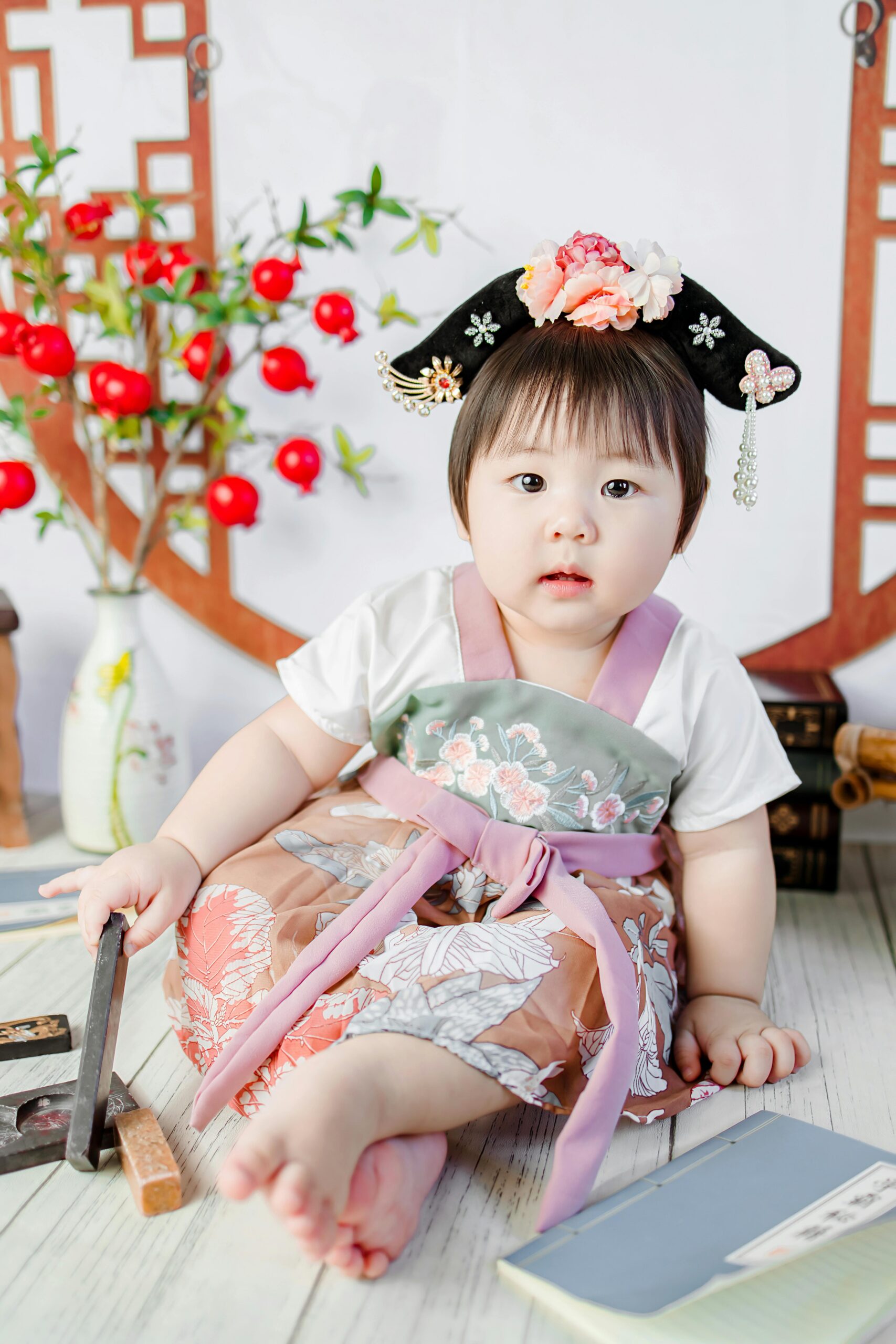 Charming baby in a colorful hanbok, sitting with traditional decor.